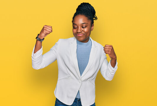 Young african american woman wearing business clothes showing arms muscles smiling proud. fitness concept.