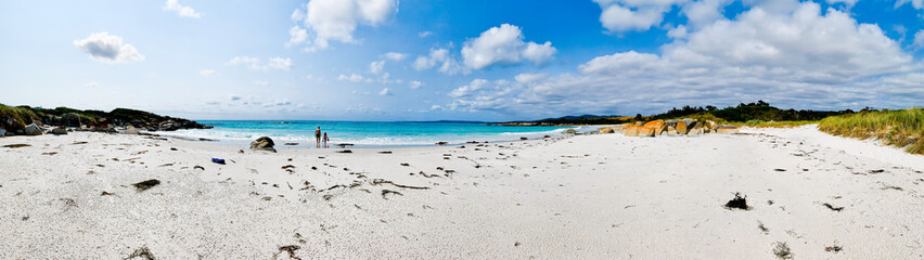 Fototapeta premium Panorama of beach at The Gardens, Bay of Fires, Tasmania, Australia with Father and daughter in the distance on the shoreline. Copy space