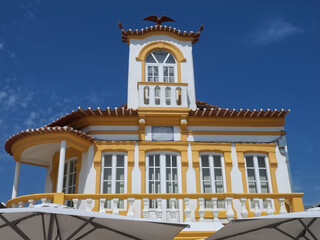 Colorful yellow wooden beach house at the promenade of Costa Nova, Aveiro, Portugal