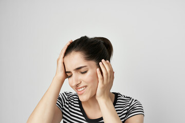 woman in striped t-shirt holds face pain in teeth dentist treatment