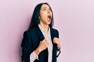 Young hispanic girl wearing business clothes angry and mad screaming frustrated and furious, shouting with anger looking up.