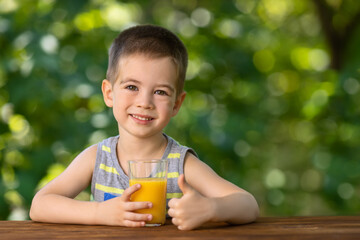 little boy with glass of juice and showing thumbs up