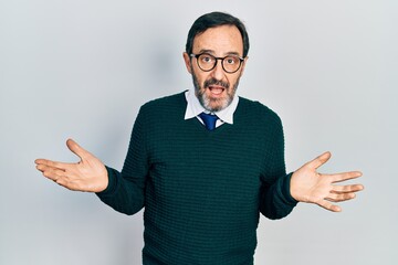 Middle age hispanic man wearing casual clothes and glasses clueless and confused expression with...