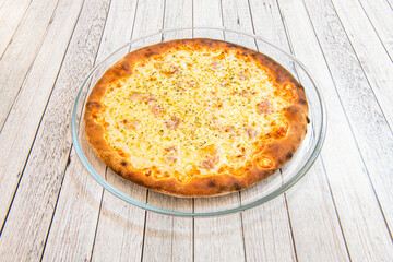 Delicious carbonara recipe pizza well toasted in the oven with lots of melted cheese, oregano and guanciale on a glass plate