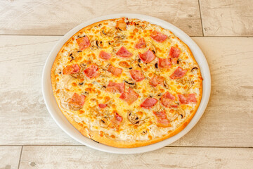 Small pizza recipe with Italian carbonara sauce with guanciale, mushroom slices, melted cheese and white onion