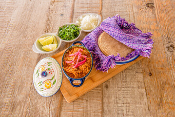 All Ingredients served in traditional Mexican containers to prepare delicious Mexican cochinita pibil tacos. Corn tortillas, onion, limes and stewed chicken meat