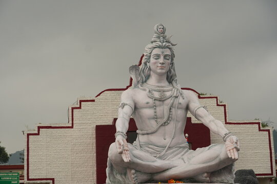 Hindu god Shiva sculpture sitting in meditation on Ganges river in Rishikesh, India,