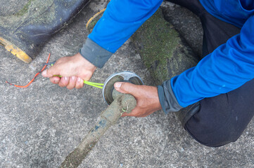 Close up on Gardener's hand holding a trimmer head and repairing weed cutter replacing parts...