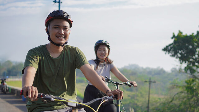 Young Asian Couple Ride Bicycle Together In The Morning