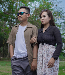 young couple holding hands and walking together in the park
