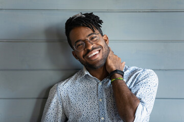 Head shot of happy Black mixed race guy with trendy haircut, glasses, toothy smile, wearing stylish...