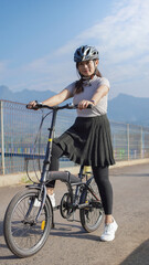young asian woman enjoying cycling when stopped in summer morning