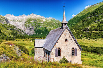 Fototapeta na wymiar Kapelle von Gletsch mit Blick auf Furkapass und Rhonegletscher, Wallis, Schweiz