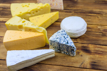 Set of various types of cheese on wooden table