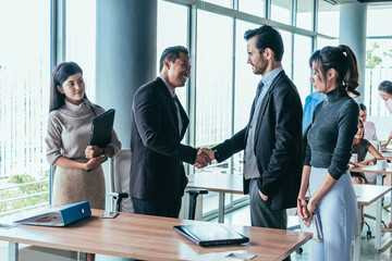 Two businessmen are negotiating a business together with their secretary at the office.