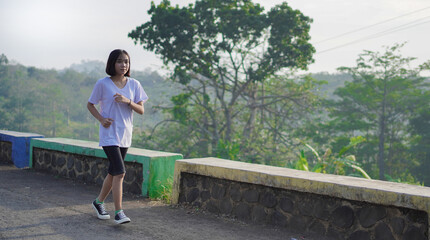 young asian woman happy on a jogging