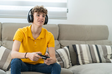 handsome young guy playing a game console with headphone and controller in his living room © MediaRaw