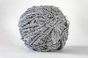 Side view of a black and white texture ball of recycled textile thread