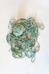 Top view of a ball of recycled textile thread and loose thread on white background