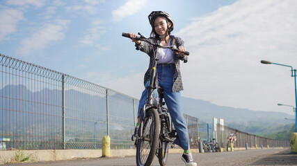 Young Asian woman break  ride bicycle  before go to work