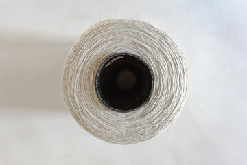 top view of a white thread roll on white background