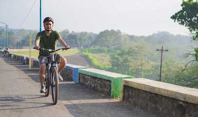 Fototapeta na wymiar young asian man ride bicycle in the morning