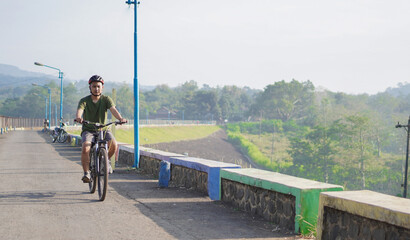 young asian man ride bicycle in the morning