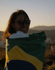 Patriot woman with brazil flag at sunset.