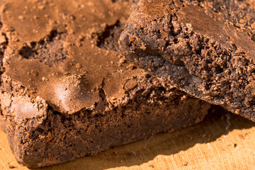 Pieces of fresh brownie on wooden background. Delicious chocolate pie. Macro Close-up. Selective focus.