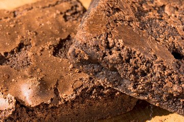 Pieces of fresh brownie on wooden background. Delicious chocolate pie. Macro Close-up. Selective focus.