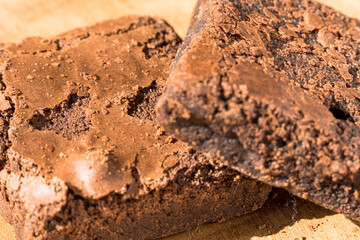 Pieces of fresh brownie on wooden background. Delicious chocolate pie. Macro Close-up. Selective focus.