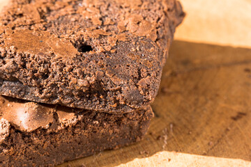 Pieces of fresh brownie on wooden background. Delicious chocolate pie. Macro Close-up. Selective focus.