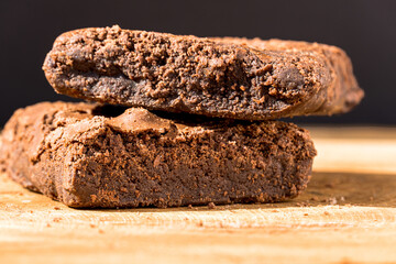 Pieces of fresh brownie on wooden background. Delicious chocolate pie. Macro Close-up. Selective focus.