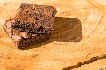 Pieces of fresh brownie on wooden background. Delicious chocolate pie. Macro Close-up. Selective focus.