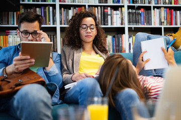 College, study, university and education concept. Group of tired students learning in library