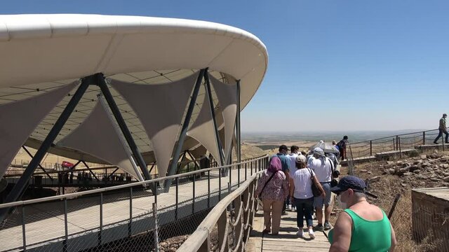 Gobeklitepe, Sanliurfa, Turkey - 15th of June 2021: 4K Group of tourists walk along the Gobeklitepe archaeological site
