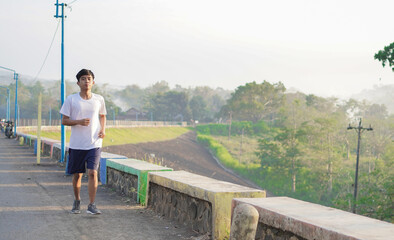 young asian man having jogging in the morning