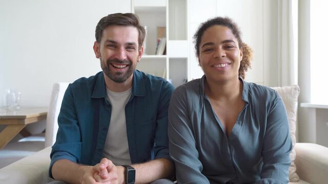 Happy multiracial couple smiling talking to camera having virtual conference