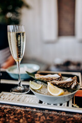 Fresh open oysters with a glass of chilled prosecco wine served on table. Seafood delicios