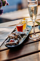 Fresh open oysters with a glass of chilled prosecco wine and set of shoot alcoholic cocktails served on table. Seafood delicios