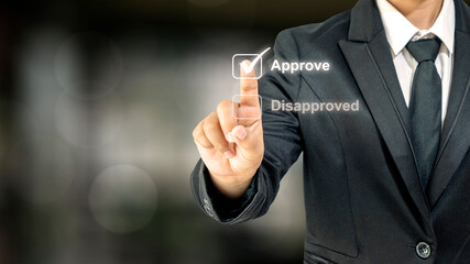 Close-up of human hand-selecting checkbox labeled approved over blurred background financial...