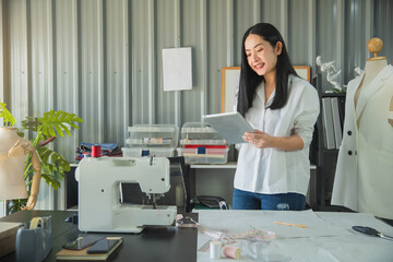 Young female fashion designer working on her designs in the studio. Fashion designer drawing sketches for new collection. Beautiful fashion woman designer drawing in studio .