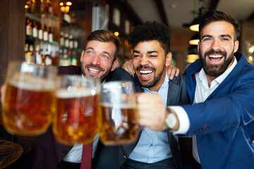 Group of friends at the pub watcing football game and drinking beer