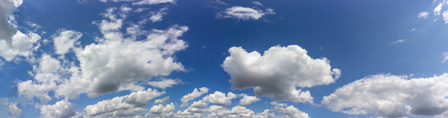 Naklejka na ściany i meble white fluffy clouds on a background of blue sky. Panorama of the sky