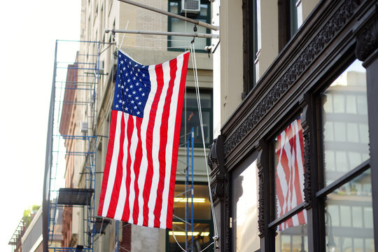American flag hanging from a wall in front of business building in New York