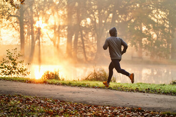 Male runner exercising at autumn in park