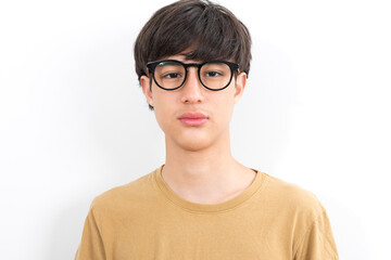 Handsome teen boy with glasses in casual brown t-shirt isolated on white background.