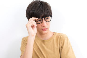 Handsome teen boy with glasses in casual brown t-shirt isolated on white background.