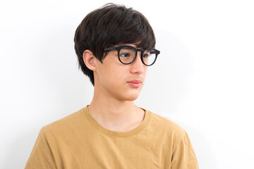 Handsome teen boy with glasses in casual brown t-shirt isolated on white background.