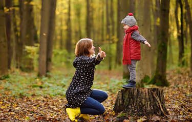 Little boy with his young mother during stroll in the forest